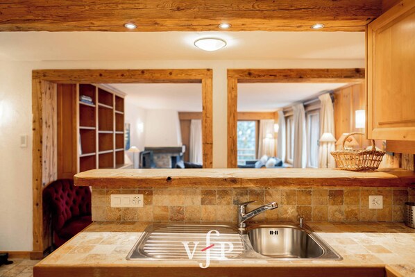 A kitchen with a wooden countertop, a stainless steel sink, and a tiled backsplash. - Very nice apartment at the heart of Verbier. It is located in 2 minutes of the central place, the sh (Verbier)