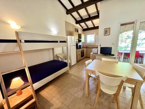 A compact kitchen with a bunk bed, a dining table, and a TV. - B4 Apartment sea and mountains view, Residence Padovani Marina, upstairs (Calcatoggio)