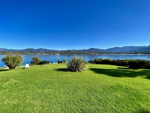 A grassy area with a clear view of a lake and mountains in the background. - B4 Apartment sea and mountains view, Residence Padovani Marina, upstairs (Calcatoggio)