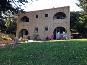 A two-story building with arched windows and a flat roof.