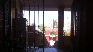 An interior corridor with a metal gate leading to a balcony. - Hostal Tres Mascaras (Ayacucho)
