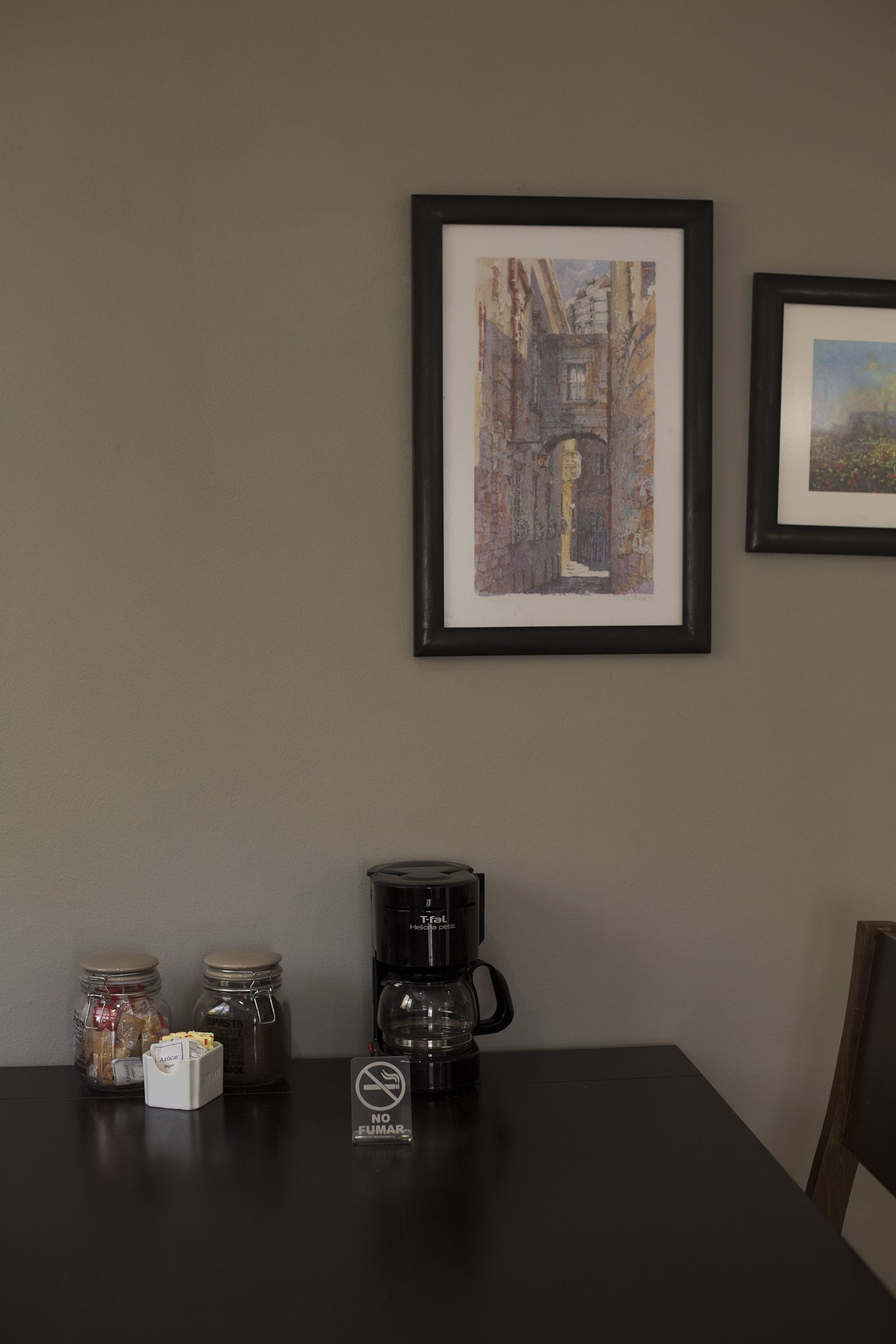 Een tafel met een koffiezetapparaat, potten en een bordje ‘ROKEN IS VERBODEN’.