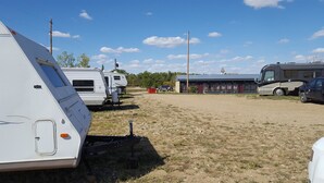 A campsite with RVs and a building with a blue roof.