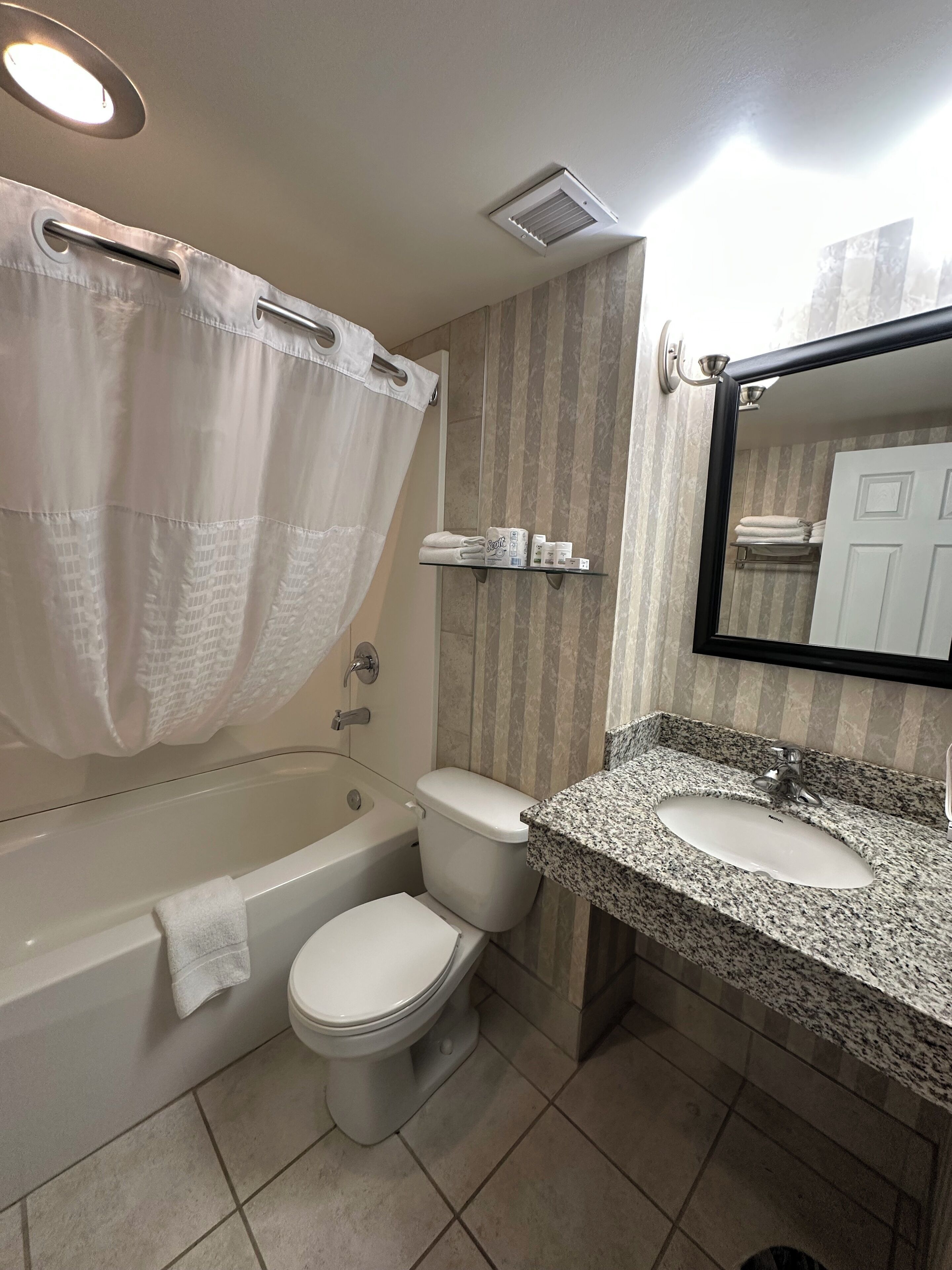A bathroom with a bathtub, toilet, and sink.
