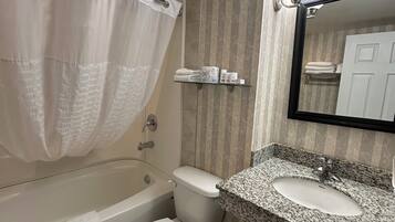 A bathroom with a bathtub, toilet, and sink.