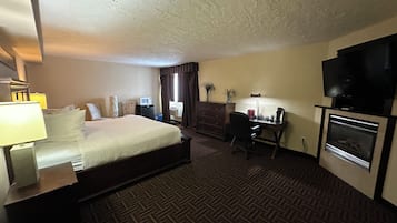 Une chambre d’hôtel équipée d’un lit, d’un bureau, d’une télévision et d’une cheminée.