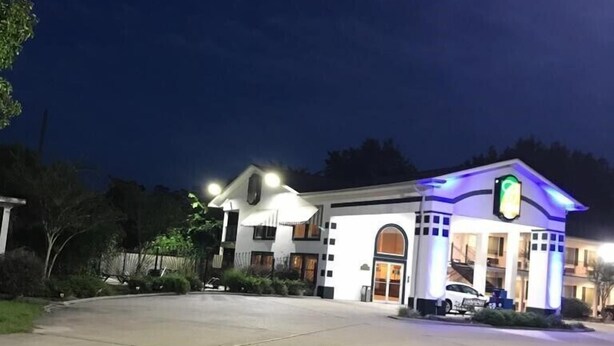 Un hotel con un amplio estacionamiento y una entrada bien iluminada.