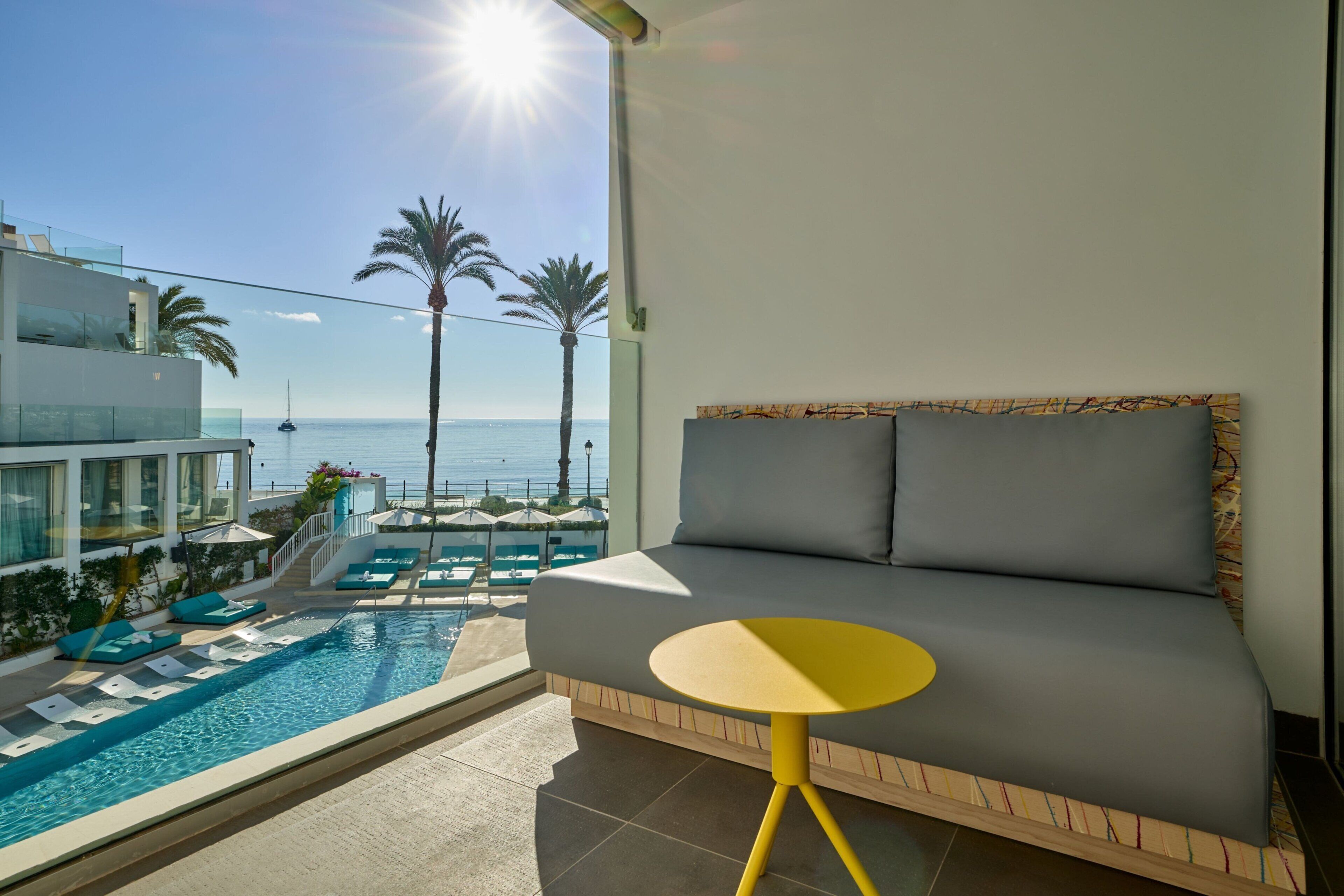 Un balcon avec une piscine, un canapé et une vue sur la mer.