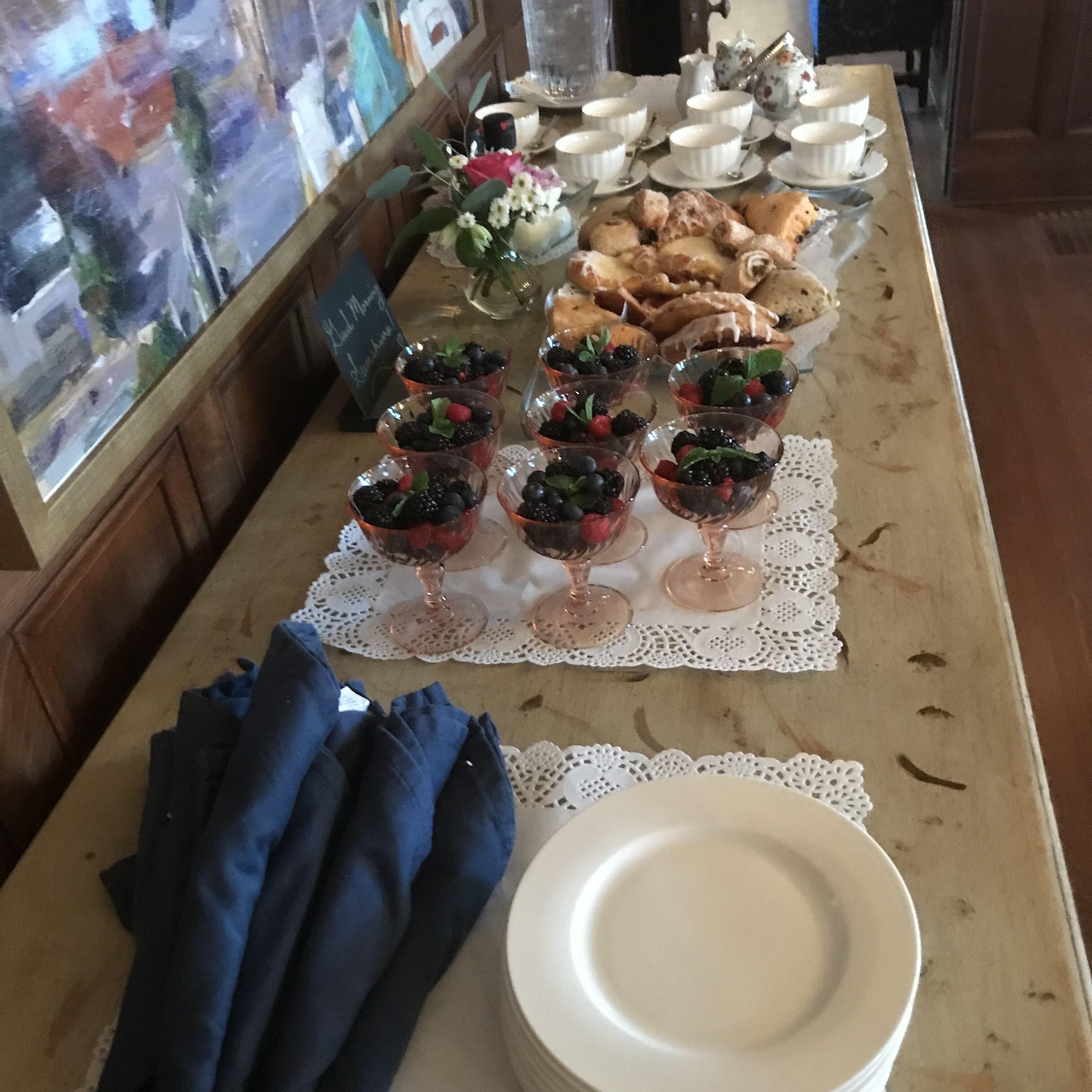 A buffet table with various food items, including fruit bowls, pastries, and a sign indicating a 'Chef's Choice'.