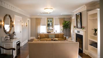 A living room with a beige sofa, a fireplace, and a chandelier.