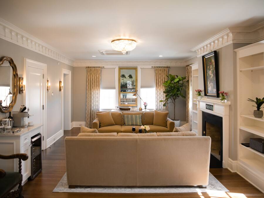A living room with a beige sofa, a fireplace, and a chandelier.