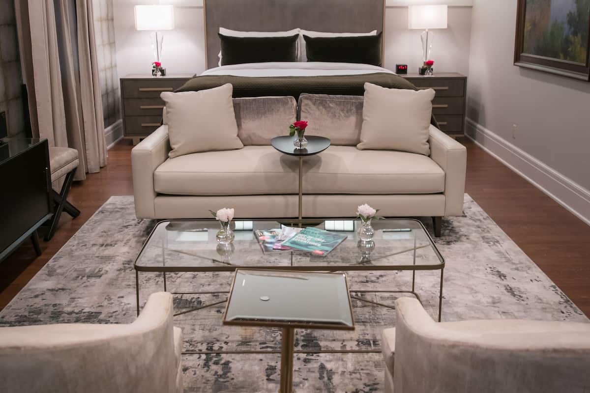 A modern living room with a sofa, coffee table, and a chandelier.