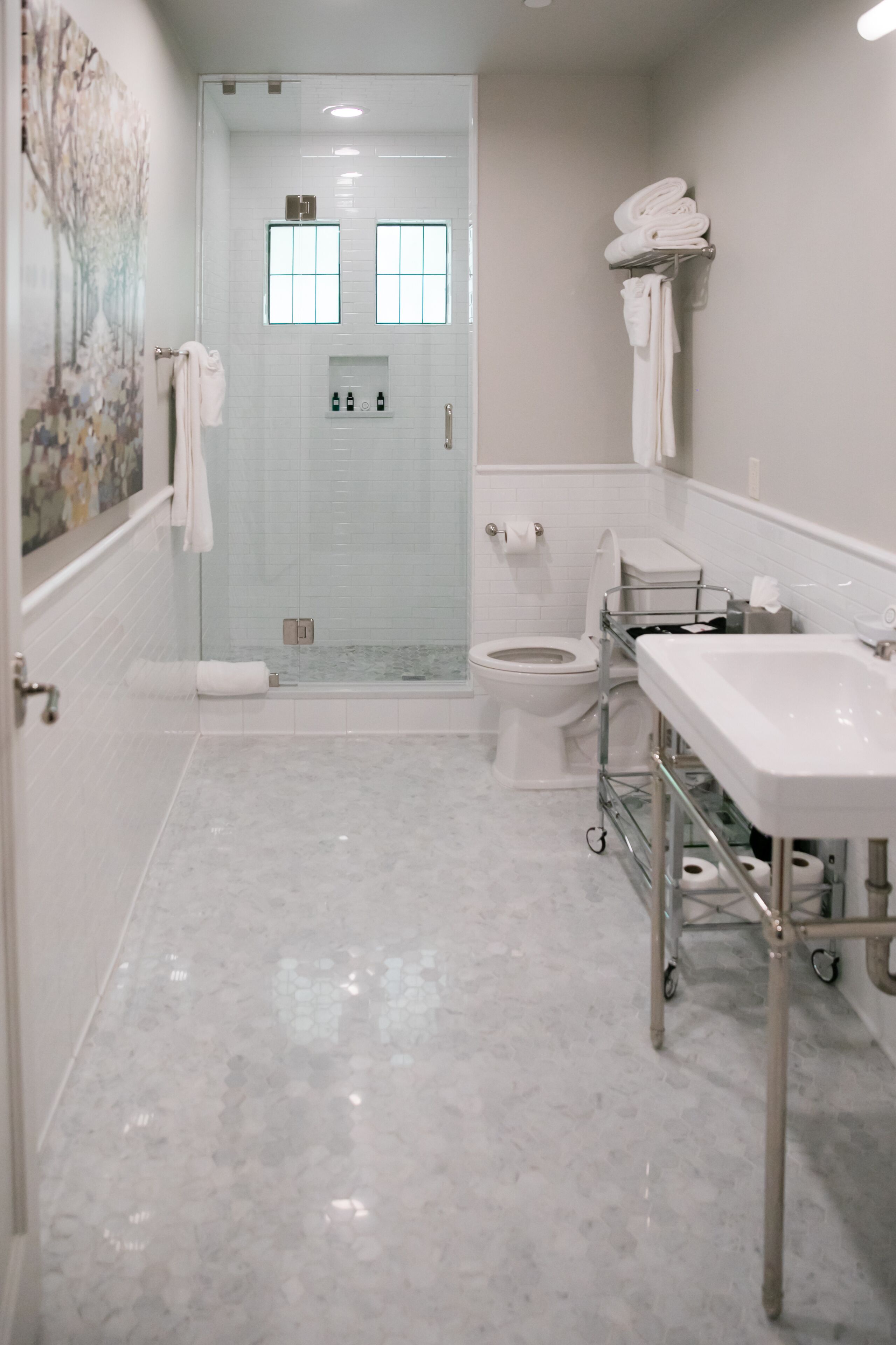 A modern bathroom with a glass-enclosed shower, a toilet, and a vanity with a sink and mirror.