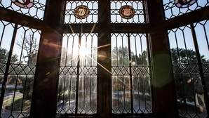 Et værelse med et stort vindue med et geometrisk mønster og glasmaleri-detaljer.