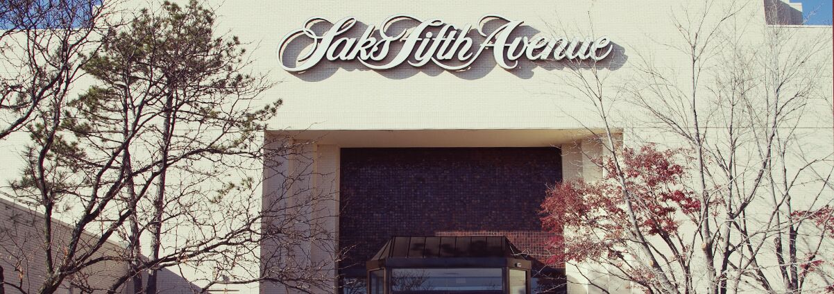 The exterior of Saks Fifth Avenue with a clear view of the entrance and surrounding trees.