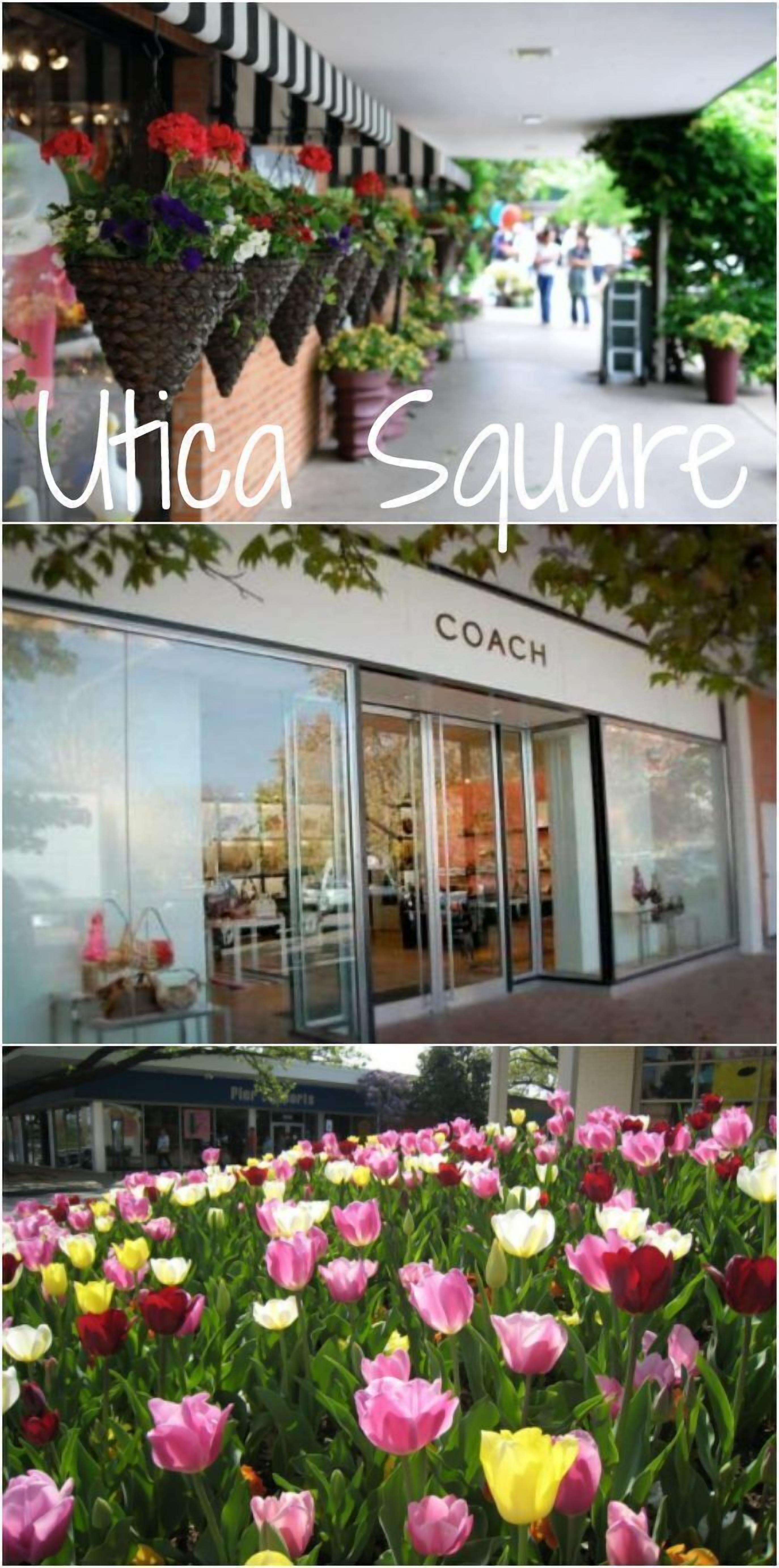 Une devanture de magasin avec une enseigne indiquant « COACH » et une rangée de paniers de fleurs suspendus au-dessus de l’entrée.