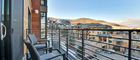 A balcony with a view of a residential area and hills.