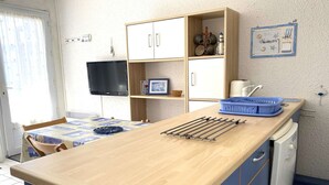 A compact kitchen with a wooden countertop, a sink, and a blue cabinet. - Cozy Apt with Terrace, 100m from St-Guirec Beach - Ploumanac'h (Perros-Guirec)