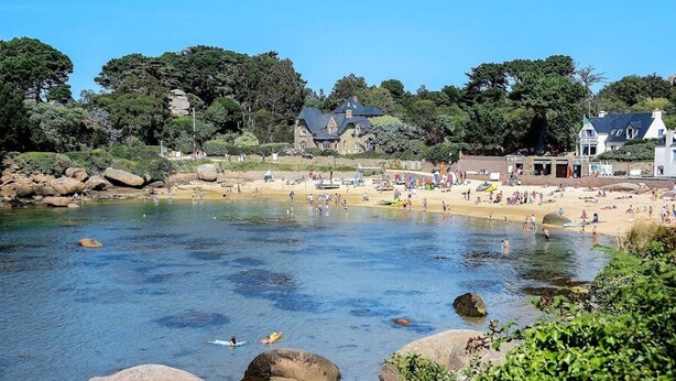 A coastal beach with clear water, large rocks, and a variety of buildings in the background. - Cozy Apt with Terrace, 100m from St-Guirec Beach - Ploumanac'h (Perros-Guirec)