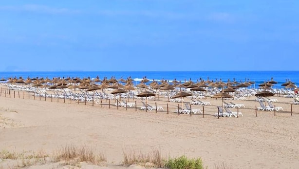 A beach with rows of sun loungers and thatched umbrellas. - Residence Sogator 2382 (Saidia)