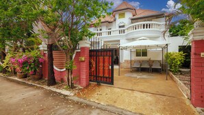 A large house with a gated entrance, a covered patio with chairs, and a star-patterned floor. - Villa 6 bedrooms near Walking Street & beach ★★★★★ (Pattaya)
