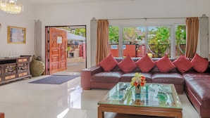 A spacious living room with a leather sofa, a glass coffee table, and a wooden cabinet. - Villa 6 bedrooms near Walking Street & beach ★★★★★ (Pattaya)