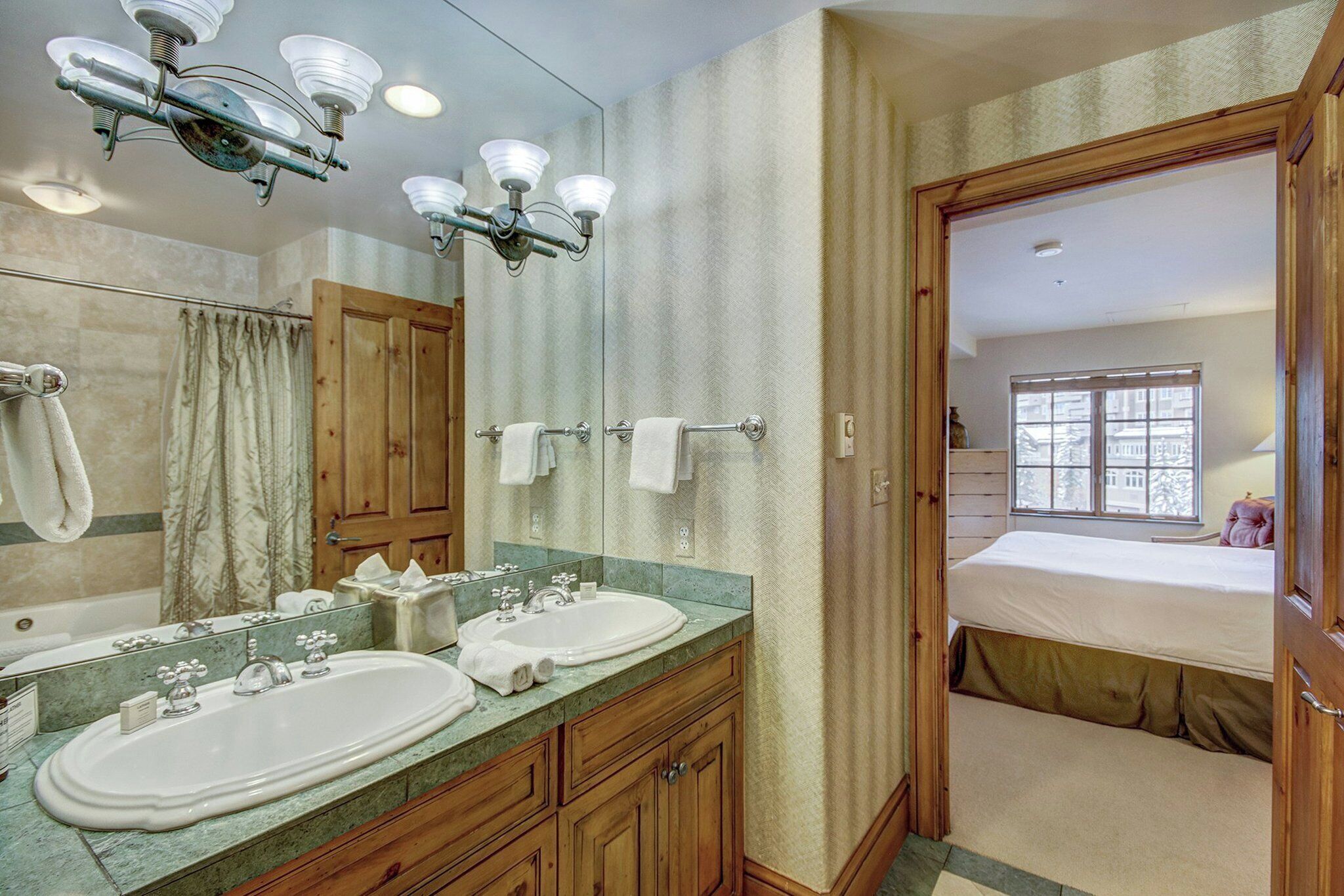 Een badkamer met twee wastafels, een spiegel en een douche.