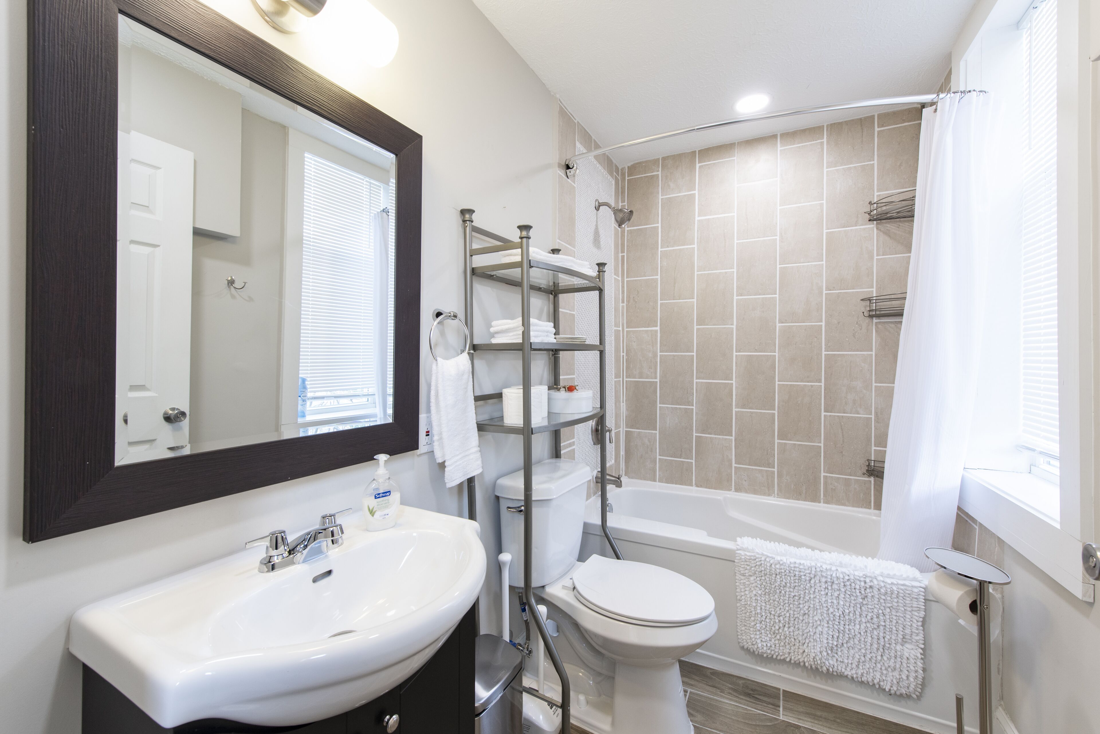 Ein Badezimmer mit weißem Waschbecken, Toilette und Duschbereich.