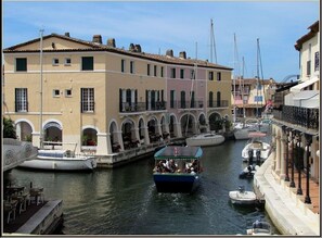 Un canal où naviguent des bateaux, un restaurant et des immeubles dotés de balcons.