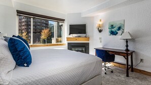 Une chambre d’hôtel équipée d’un lit, d’un bureau, d’une télévision et d’une cheminée.