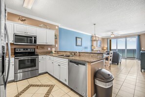 A modern kitchen with stainless steel appliances, a dishwasher, and a granite countertop. - Emerald Isle 703 2BR/2BA 7th Flr Slps 8 Early Booking Discount 2 Beach Chairs (Panama City Beach)