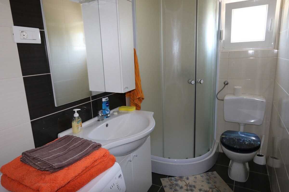 A bathroom with a sink, toilet, and shower.