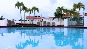 A swimming pool with lounge chairs and palm trees. - Rio Mar Beach Resort - Time Magazine TOP 100 World's Greatest Places 2018 (Rio Grande)