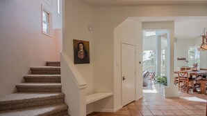 A staircase leading to a second floor, a dining area with a table and chairs, and a door leading to another room. - View of White Sands/Tularosa Basin, hot tub & a/c in the Village of Cloudcroft! (Cloudcroft)