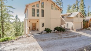 A two-story house with a large front porch, a garage, and a driveway. - View of White Sands/Tularosa Basin, hot tub & a/c in the Village of Cloudcroft! (Cloudcroft)