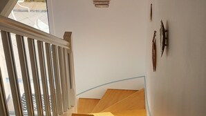 Een trap met een houten leuning en uitzicht op de bovenverdieping.