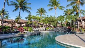 A pool area with palm trees, lounge chairs, and a building with a balcony. - 🏖️2 Cal King Townhome | Pickleball + Pools | Near A-Bay (Waikoloa)