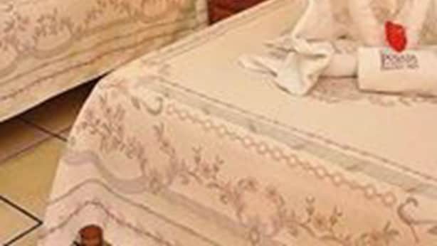 A hotel room with two beds, each adorned with a heart-shaped towel arrangement and a small red heart. - Hotel Camelinas Área Blanca (Patzcuaro)
