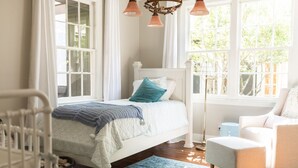 A bedroom with a bed, a chair, a floor lamp, and a window with curtains. - Large family home - walking distance to campus and square! (Oxford)