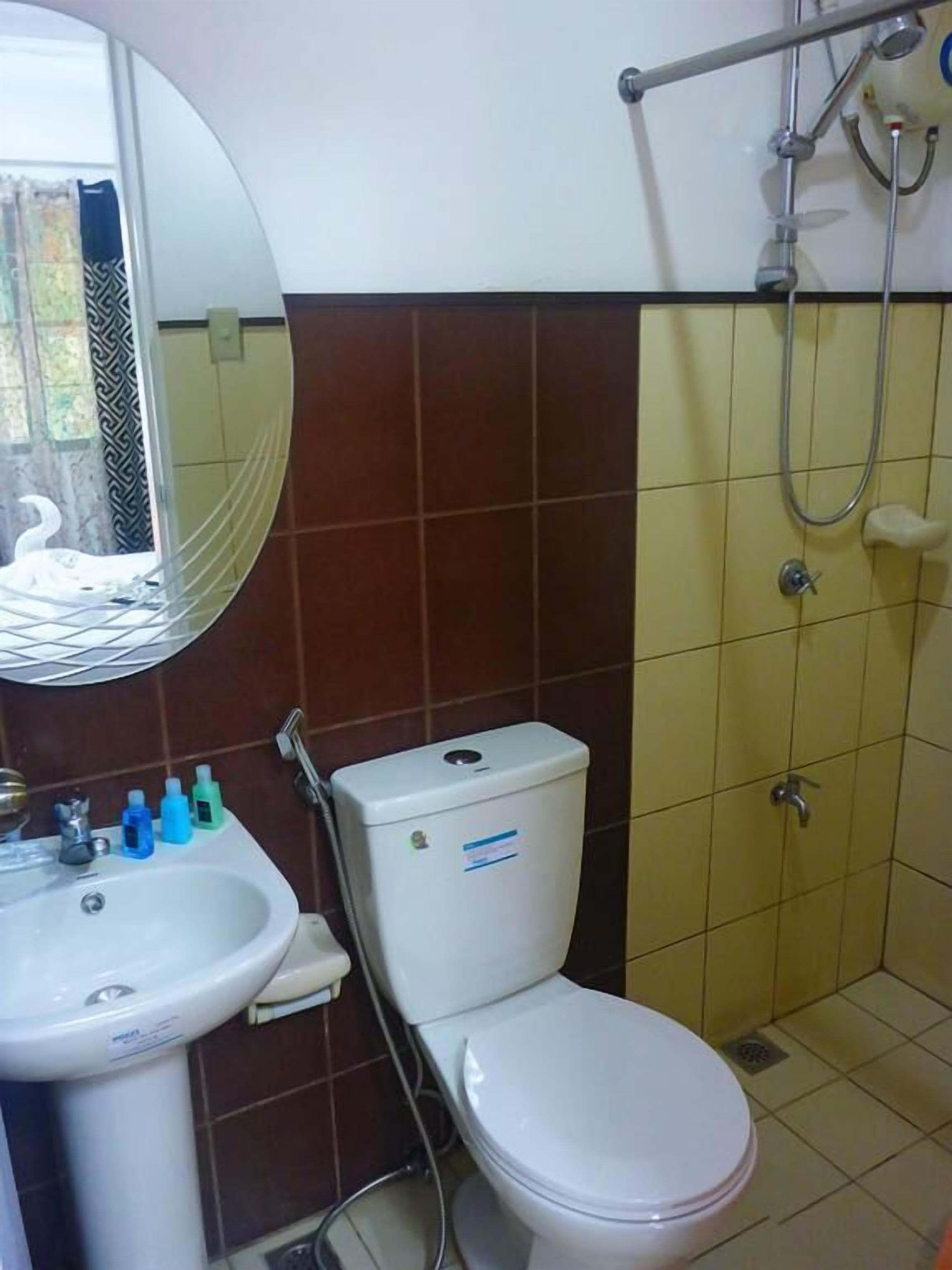 A bathroom with a toilet, sink, and shower.
