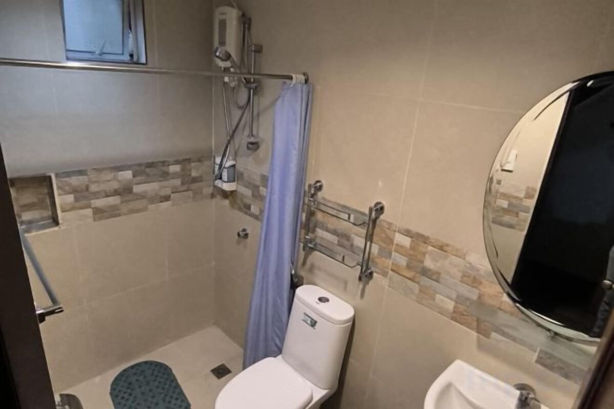 A bathroom with a shower, toilet, and sink.
