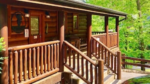 A wooden lodge with a porch and a 'No Pets Allowed' sign.