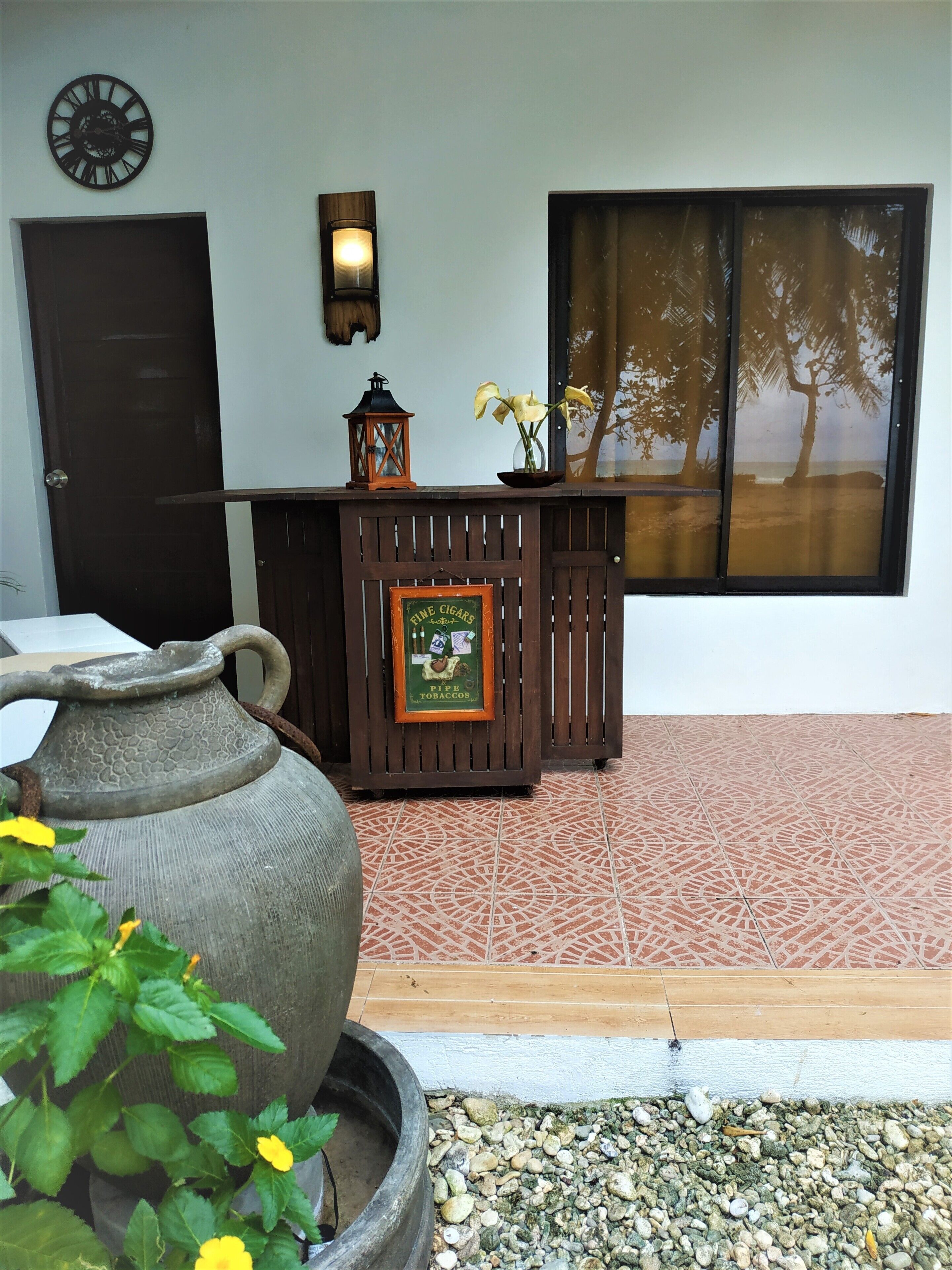 A reception area with a wooden counter, a framed sign, a large vase, and a decorative lantern.