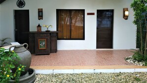 A traditional house with a tiled entrance, a wooden door, a wall clock, and a sign reading "Cebu". - Carolina del Mar (Samboan)