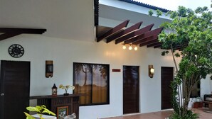 A modern building with a large window, a door labeled "Cebu," and a decorative wall piece. - Carolina del Mar (Samboan)