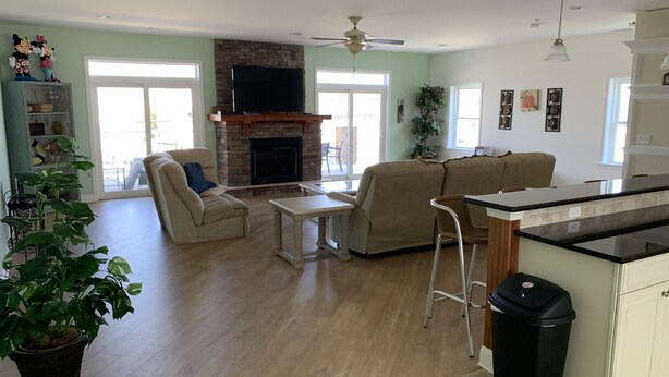 A spacious living room with a fireplace, a dining area, and a kitchen with a bar. - PRICE REDUCED Beautiful 3 Bedroom, 21/2 Bath Condo,walking distance to the beach (North Wildwood)