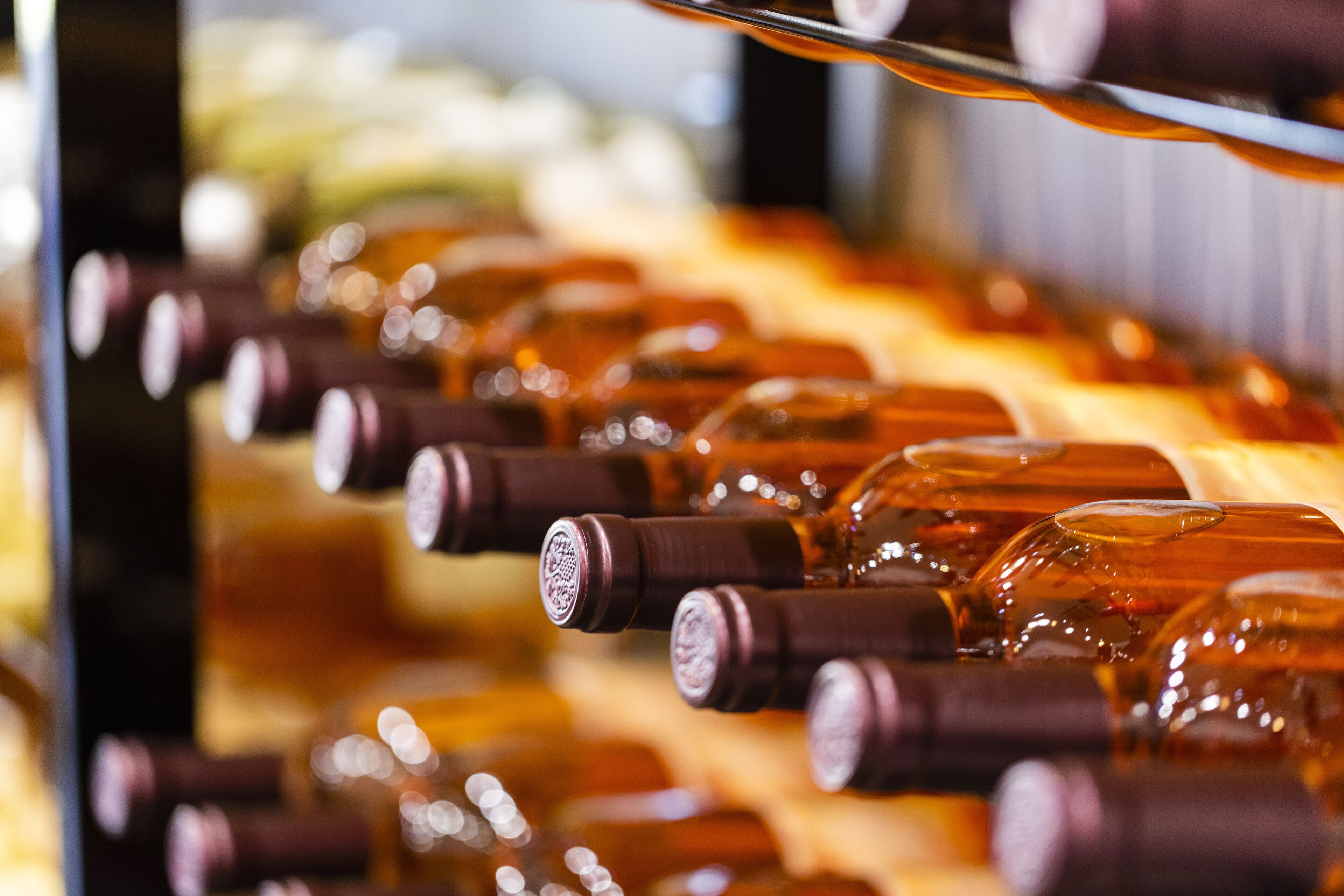 A row of bottles with corks, likely in a storage or display setting.