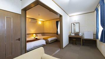 A hotel room with a bed, a desk, a chair, and a bathroom.