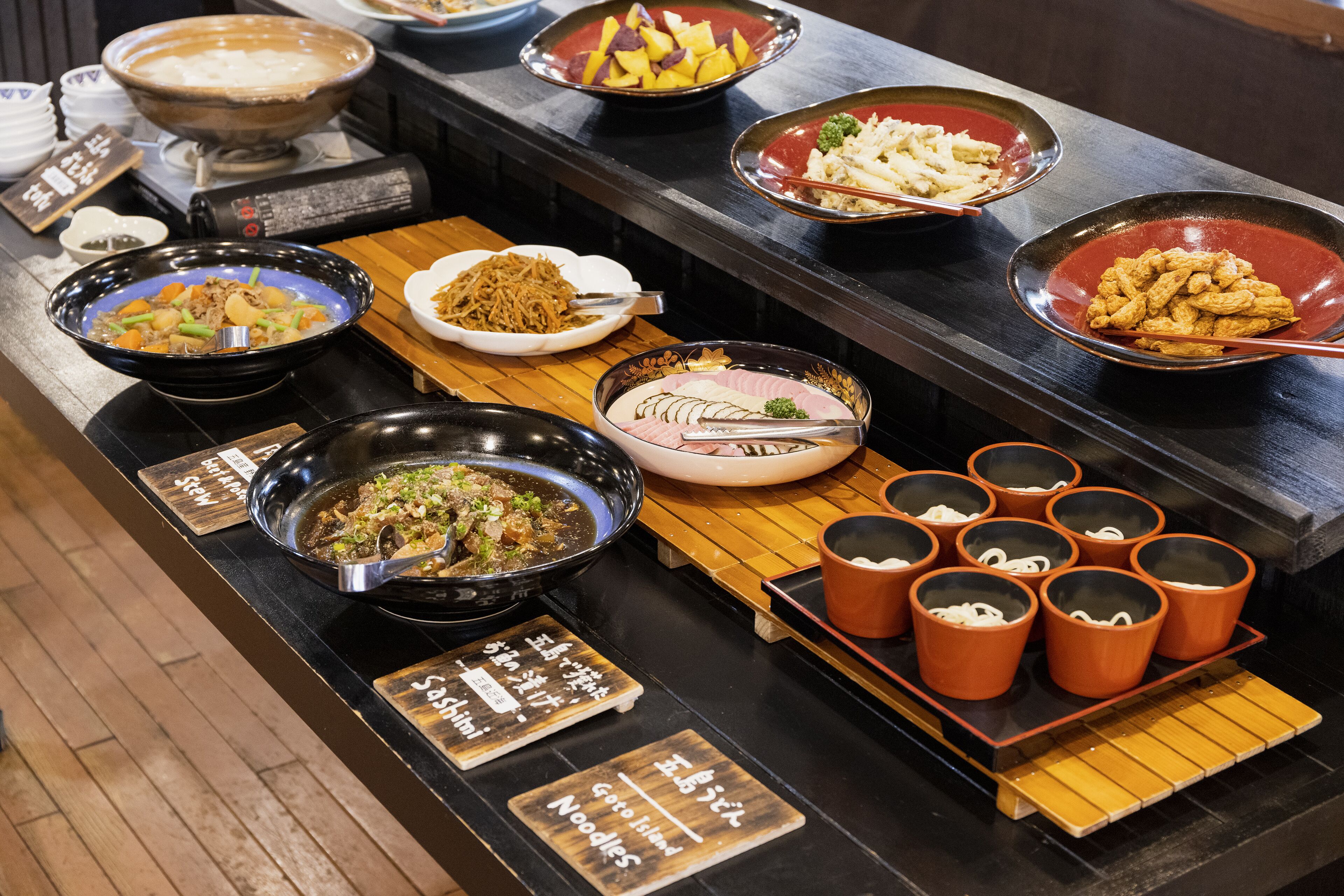 A buffet with various dishes and bowls of food.