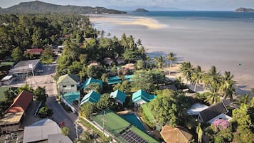 A coastal village with houses, a beach, and a mountain in the background.